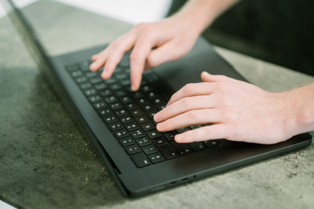 Individual typing onto a laptop to highlight Cyber Security Myths