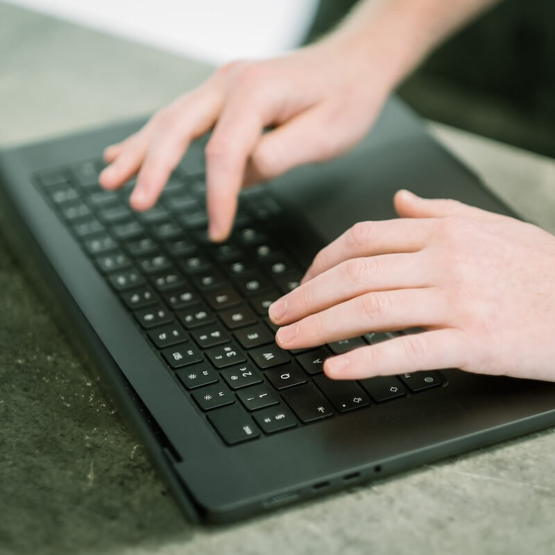 Individual typing onto a laptop to highlight Cyber Security Myths